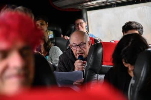 Julian Walton reading historic facts on the bus to Passage East DIVE at Spraoi 2024