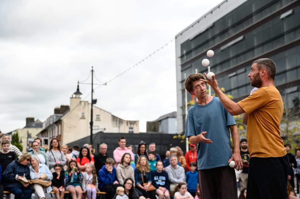 outdoor arts performers surrounded by audiences
