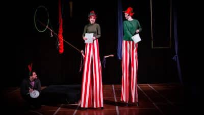 Two young people on stilts dressed in festive Christmas outfits
