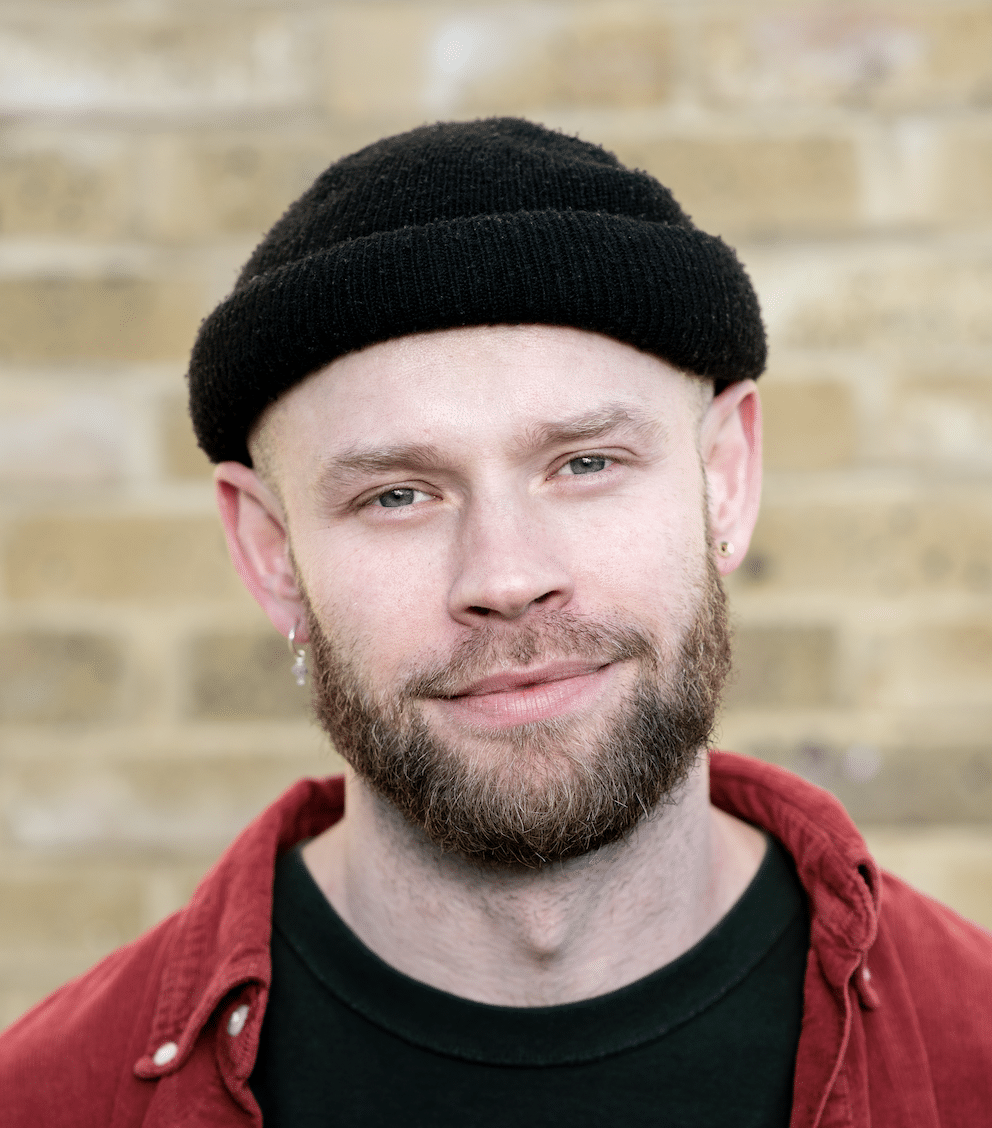 Headshot of a man with a beard wearing a beanie